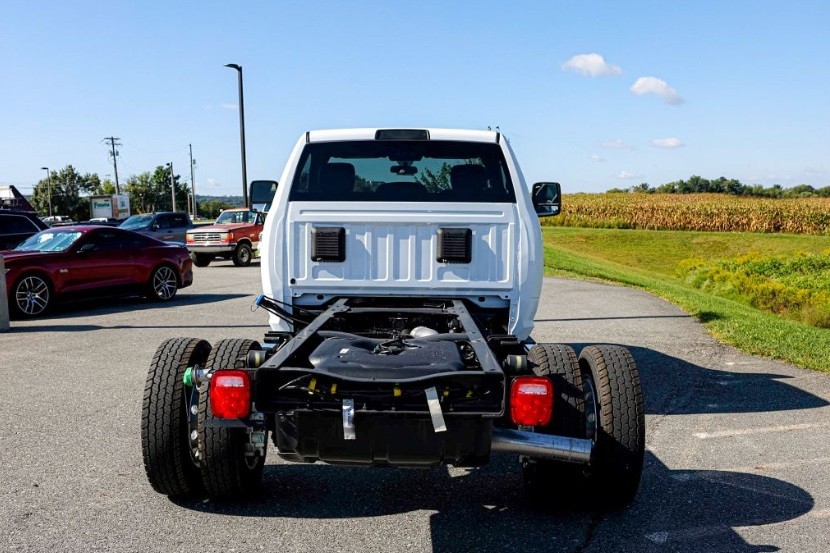 White pickup truck without bed near cornfield.