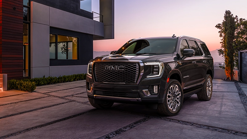 2025 gmc yukon denali in right-hand drive-by-autogroup-international parked in driveway during a sunset