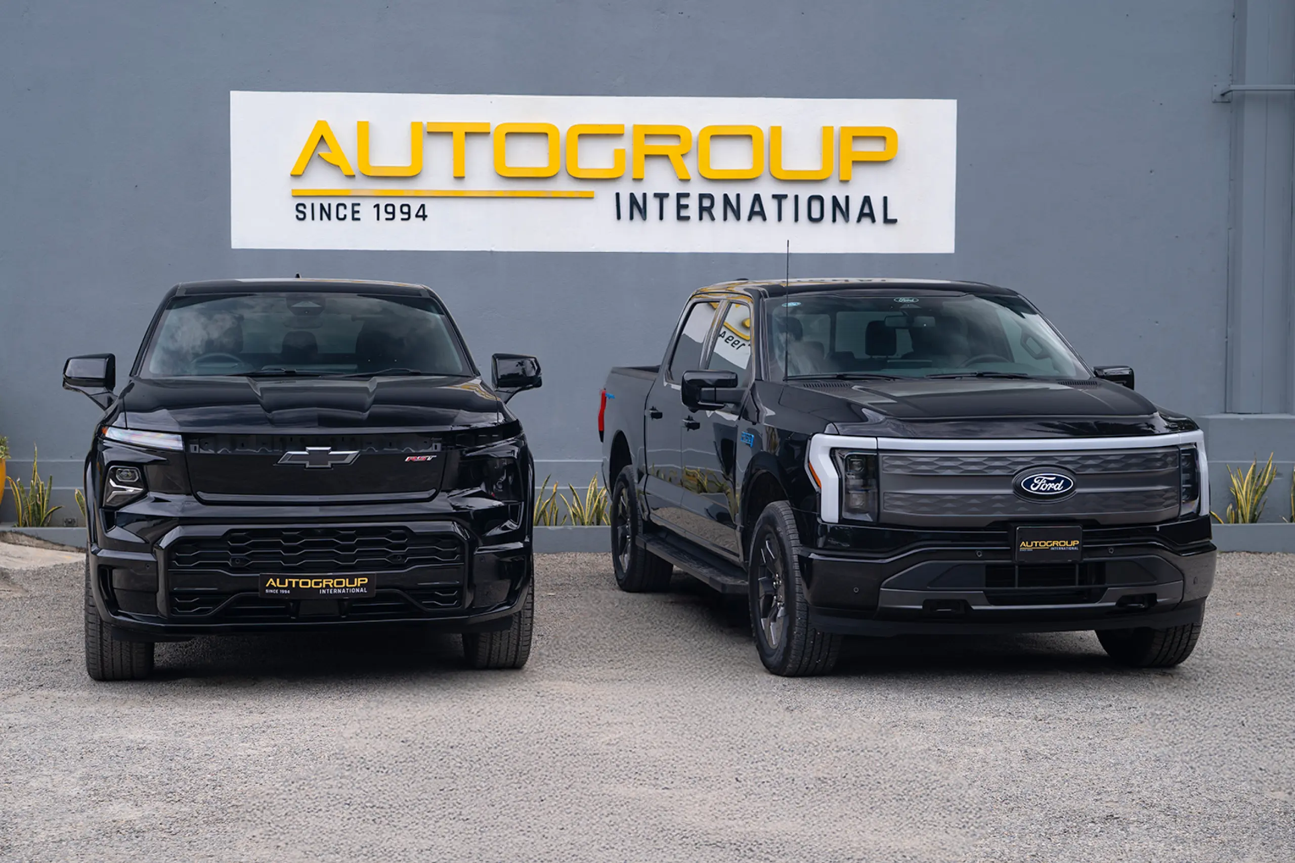 Black Chevrolet Silverado EV and Ford F 150 Lighting pickup trucks at Autogroup International