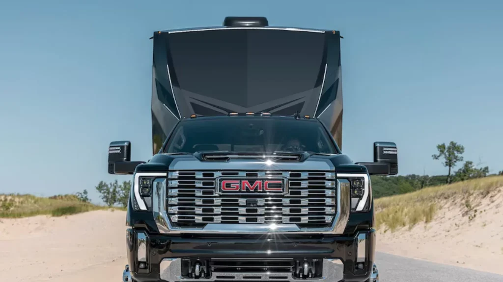 GMC truck towing large trailer on sunny road