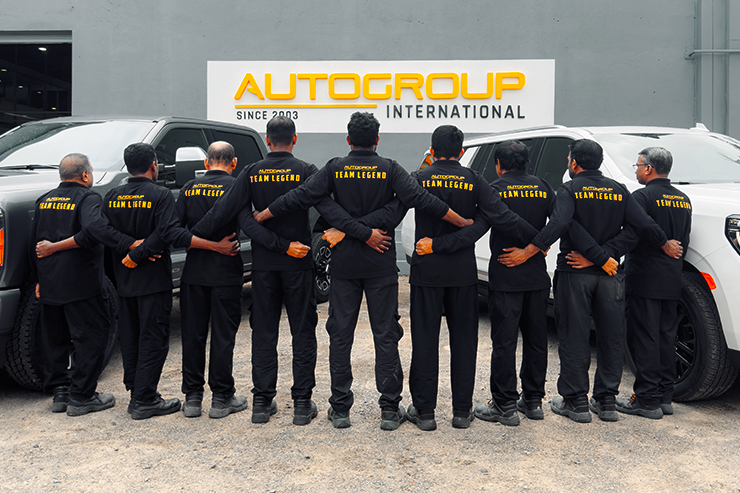 Autogroup International - a group photo of 15 technicians facing back to camera with Team legend written on back of shirt. Symbolic of our 20+ years of experience