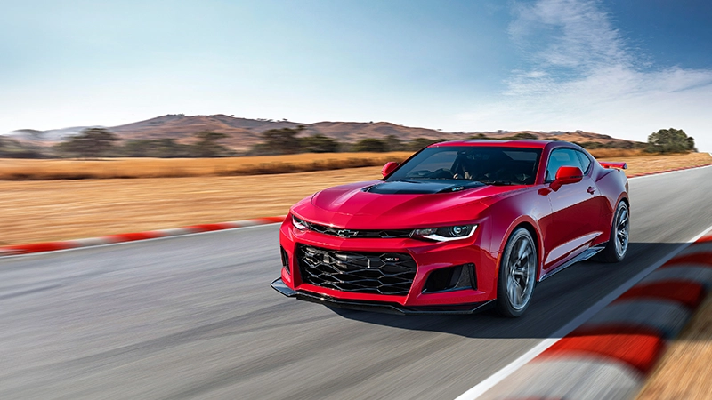 chevrolet camero in red speeding down raceway by_autogroup_international