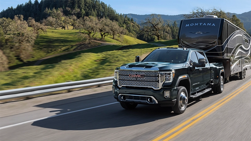 Driver front 3/4 view of 2023 GMC Sierra 3500HD towing a fifth wheel